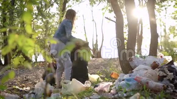 小男孩正在帮助妈妈在秋日把森林里的垃圾清理干净人们正在把垃圾分类视频的预览图
