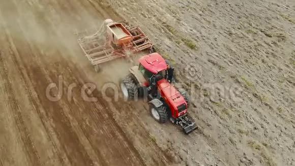 农夫开着一辆拖拉机装有一个容器用来播种春天在田间工作的粮食作物视频的预览图