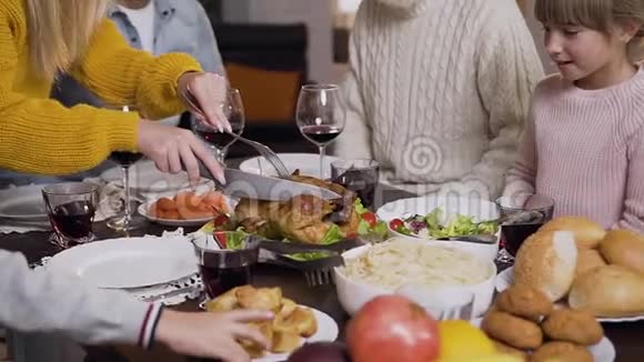 在家庭晚餐时用叉子和刀切烤火鸡的女性双手合拢视频的预览图