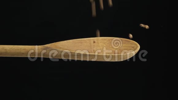 落粒荞麦装满勺子从木勺里掉出来慢动作视频的预览图