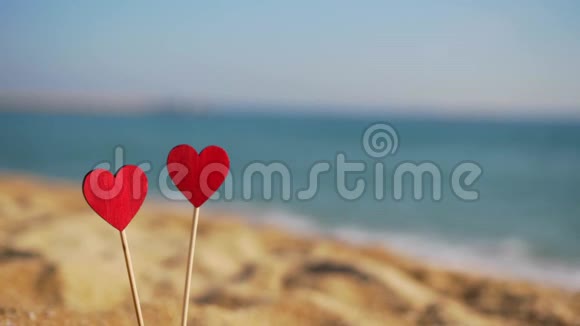 美丽的红木心在沙滩上的海天相接视频的预览图