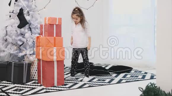 可爱的孩子为她的朋友和家人准备了一堆带白色丝带的红色礼品盒数了数然后睡着了视频的预览图