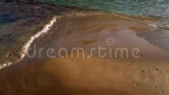 柔软的海浪在海滩的沙滩上破碎视频的预览图