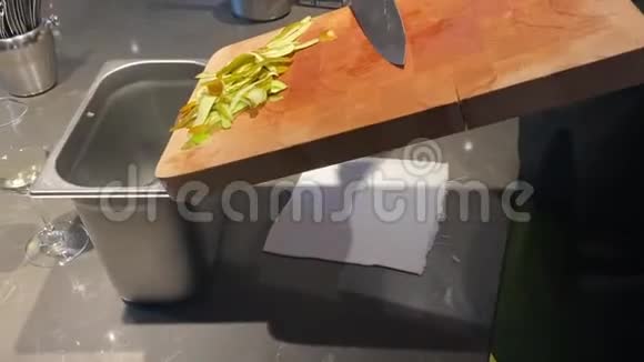 厨师用刀子从木切割板上取出削皮水果的残骸视频的预览图