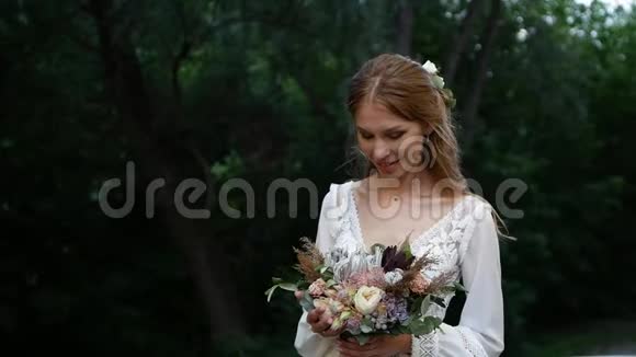 一个带着一束美丽的花的年轻女孩看着相机微笑视频的预览图