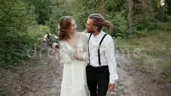 恋爱中的情侣在森林的道路上接吻和微笑视频的预览图