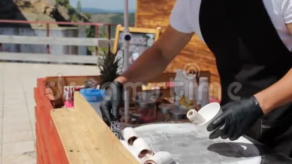 不明身份的厨师正在度假村夏季阳光明媚的炎热天气做美味的冰淇淋卷小型餐厅视频的预览图