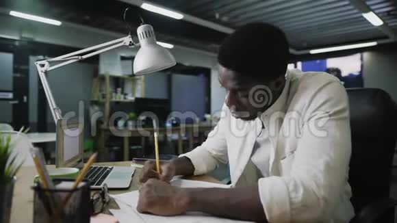 疲惫的非裔美国商人在办公桌前工作扔纸相机滑动视频的预览图