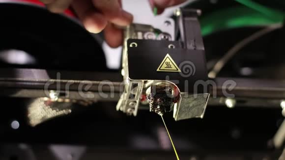 3D打印机头手推绿色电缆打印的黄色塑料线视频的预览图