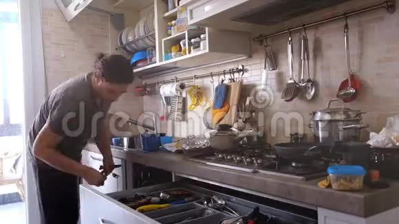 男人在公寓里做家务厨房里装洗碗机在煤气炉上给女儿做饭视频的预览图