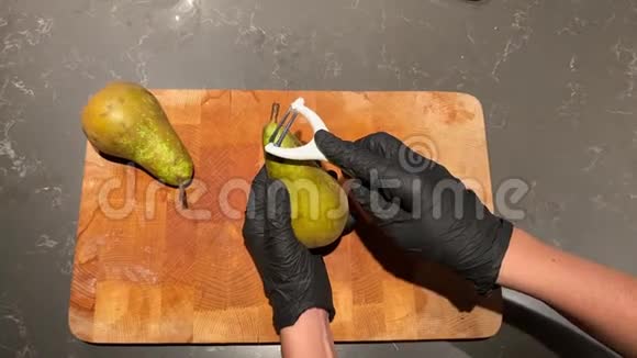戴着黑手套的女人用切割刀清洗梨皮视频的预览图