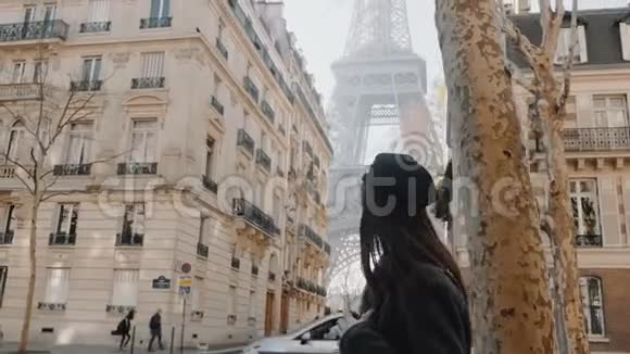 电影院侧景优雅的女人沿着巴黎大街散步阳光明媚的埃菲尔铁塔被看到房屋之间缓慢的运动视频的预览图