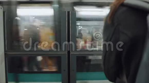 电影特写镜头跟随女性在站台门等待地铁列车进入列车慢速运动视频的预览图