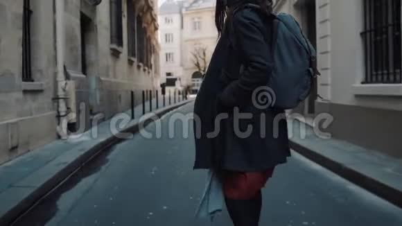 特写镜头跟随美丽优雅的女人背着背包沿着秋天的巴黎街道缓慢地走着视频的预览图