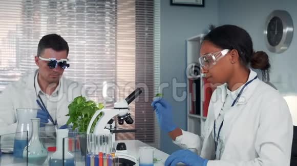 在现代研究实验室黑人女科学家在显微镜下观察有机物视频的预览图