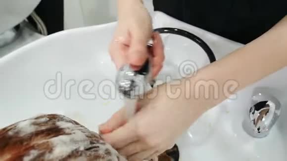 美容设计师准备洗她的客户头发后去先用手腕试试水温头发护理视频的预览图