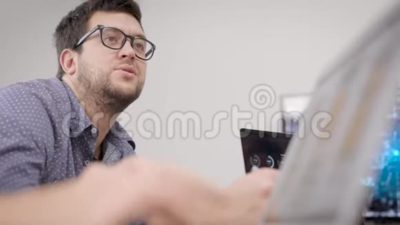 在会上一个男人在会议室里和同事在一起一个戴眼镜的程序员讨论开发视频的预览图