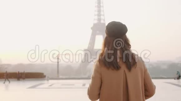 镜头跟随快乐的当地博客女性沿着巴黎的特罗卡德罗广场漫步到雾蒙蒙的日出埃菲尔铁塔慢动作视频的预览图