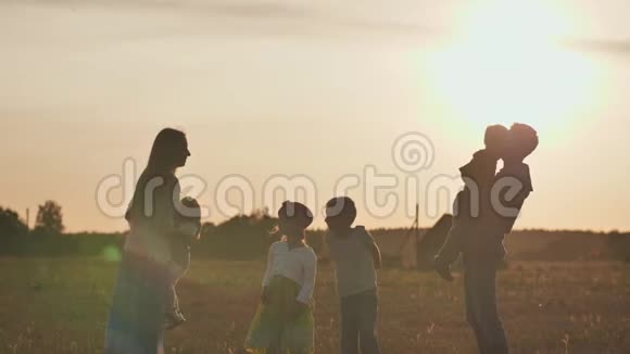 幸福大家庭的概念快乐的父母在夕阳的背景下把他们的孩子扔起来视频的预览图
