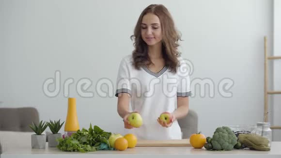 年轻有技能的女人站在现代厨房时把苹果放在桌子上健康食品的概念职业视频的预览图