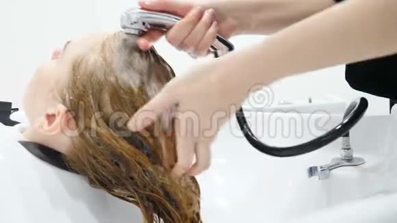 化妆和发型美的概念用自来水洗姜发将人的头发向焦点倾斜视频的预览图
