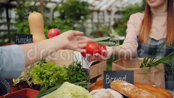 卖菜的女孩用纸袋包装新鲜蔬菜视频的预览图