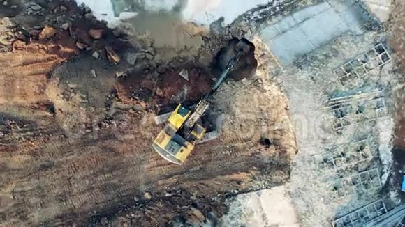 俯视图一台挖掘机从地面楼洞口抓土施工过程视频的预览图
