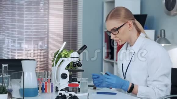 实验室里的女化学教授用吸管把肥料滴在什么东西上视频的预览图