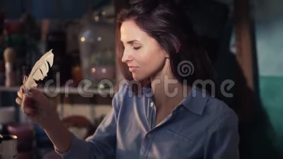 有魅力的女人坐在桌子旁边正在用羽毛写东西后来她生气了毁了她视频的预览图