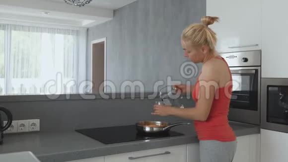 厨房里的女人正在炉子上准备用胡萝卜炖扁豆并在锅里加了一杯干净的东西视频的预览图