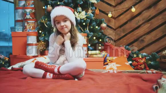 圣诞老人坐在圣诞树附近指着铜空间的文字或产品在她身边视频的预览图