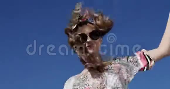 一阵强风吹在美女模特身上穿着时髦的连衣裙戴着游艇上的太阳镜视频的预览图