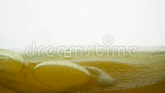 金色液体表面有气泡和空气滴玉米油与油一起倒入透明视频的预览图