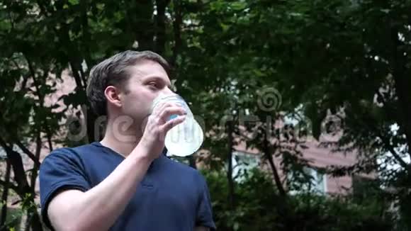一个男人从一个透明的塑料瓶子里喝酒视频的预览图