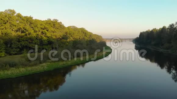 一架无人机在蜿蜒的河流上飞过一个风景名胜区它反映了巨大而茂密的树木视频的预览图