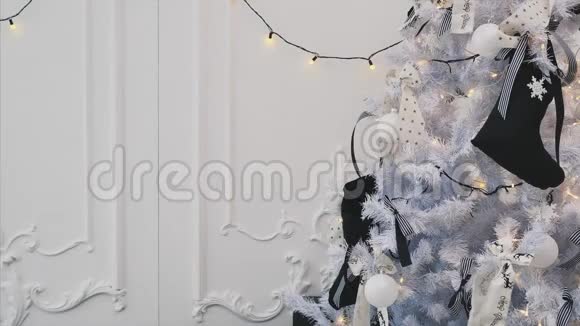 小孩子在圣诞树树枝上放条纹弓看上去很满意伸出大拇指微笑着视频的预览图