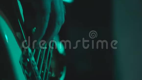 一个男人在舞台上弹低音吉他手工特写视频的预览图