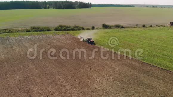 一个农民在现代拖拉机上耕作尘土飞扬的土壤播种着美丽的夏田视频的预览图