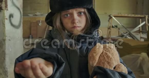 无家可归的白人女孩穿着肮脏的冬天衣服抱着泰迪熊要求施舍无家可归者视频的预览图