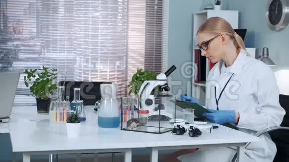 实验室里聪明的女化学科学家写实验结果视频的预览图