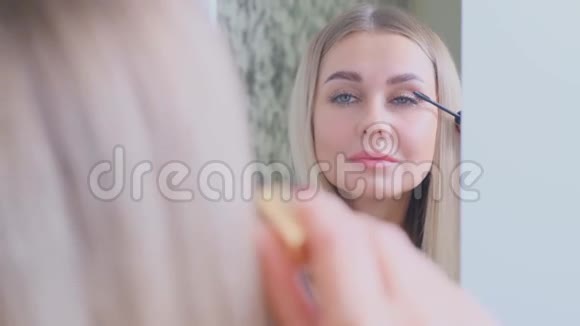 在镜子前化妆的女人视频的预览图