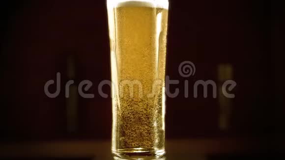 特写慢镜头冷光啤酒在一个高玻璃与水滴在酒吧背景快来点啤酒微波炉视频的预览图
