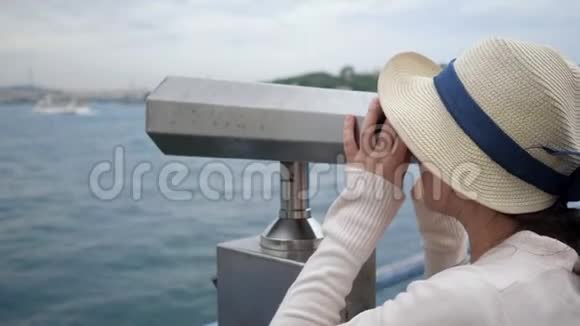 女人透过望远镜观察堤岸的海岸视频的预览图
