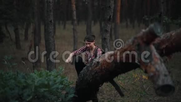 女人在森林的树干上挣扎放松视频的预览图