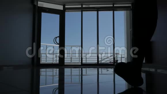 一个男人从海滨酒店的玻璃门出来的剪影美丽的海景视频的预览图