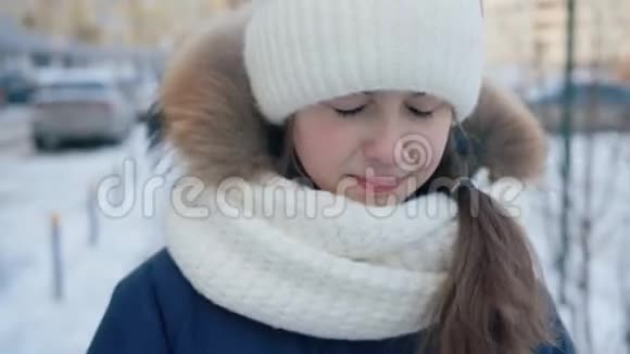 这幅画像使那个在冬天大街上哭泣的年轻女孩心烦意乱雪城街冬日散步的愁眉苦脸女孩视频的预览图