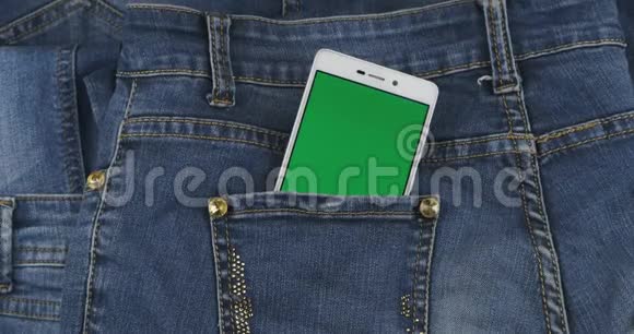 放大带有绿色屏幕的智能手机从牛仔裤口袋里伸出概念视频的预览图