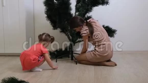 快乐的母亲和小女儿在家收集圣诞树装饰品准备圣诞节和新年视频的预览图