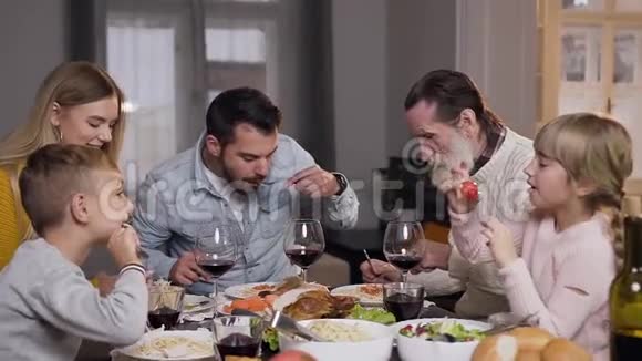 吸引人的幸福不同的一代家庭在家庭宴会周围享用晚餐视频的预览图