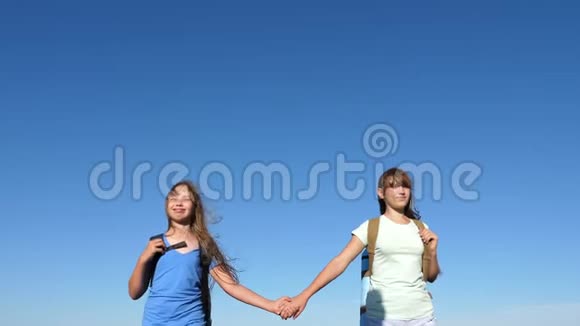 女孩们女游客在蓝天的背景下牵手特写镜头团队合作游客青少年妇女视频的预览图